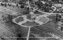 Aerial view of a square temple structure, surrounded by thousands of people.