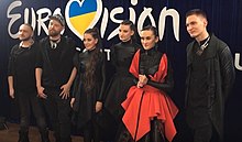 Image of Go_A members posing dressed in black (except for Pavlenko in red)