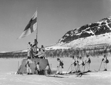 Finnish troops raise a flag on the three-country cairn in April 1945 at the close of the World War II in Finland. Kolmen valtakunnan rajapyykki 27.4.1945.png