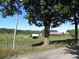 Gårdsbyggnader och landskap norr om Mo kyrka