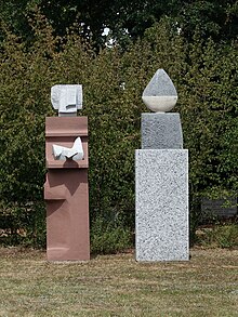 Lorenz Balmer-Gerber (1916–2004), Helen Balmer-Gerber (1924), Gemeinschaftswerk. Skulptur, Frau mit Weihgabe und Wächter, 1993. Granit, Marmor, Kalk- und Sandstein für das anonyme Gemeinschaftsgrab, Friedhof am Hörnli, Basel.