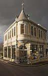 Semi-detached double storey Victorian commercial building with splayed corner treatment and a corner turret with pressed steel tiles; typical Victorian plaster detailing with elaborate moulding around windows and pronounced eaves treatment; typical timber Type of site: Commercial Current use: Offices. The historic Old Wynberg Village is an area of considerable character, as well as being of historical, architectural and environmental importance. It is one of the few areas close to the City of Cape Town which have retained their historical character.