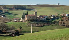 Photo de l'église de l'Assomption : une église à nef unique à proximité de quelques maisons au milieu des champs