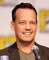 Picture of a man's head, sitting in front of a microphone