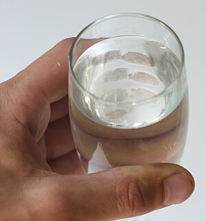 English: Fingerprints on a glass of water made...