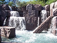 Водопады, перетекающие через каменные блоки в бассейн