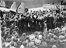 British Prime Minister Neville Chamberlain after landing at Heston Aerodrome following his meeting with Adolf Hitler MunichAgreement.jpg