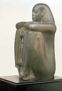 Gouverneur de Saïs, porteur de naos. Statue cube, r. de Psammétique Ier Grauwacke, H. 30 cm. Met[4]