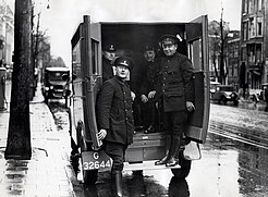 Amsterdamse politieagenten bij een arrestantenwagen, november 1933