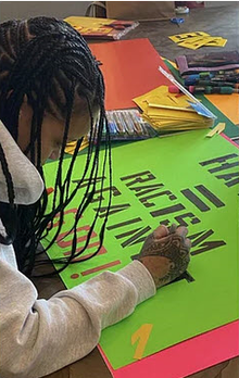 Rihanna writing a protest sign