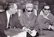 Две женщины в солнечных очках сидят рядом с мужчиной