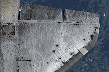 Grey spacecraft wing at aircraft altitude