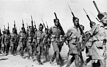 Soldiers of the 2nd NZEF, 20th Battalion, C Company marching in Baggush, Egypt, September 1941. 20th Battalion infantry marching in Baggush, Egypt, September 1941.jpg