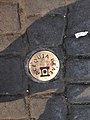 Placa de cobre en el suelo indicando el trazo original de la acequia.