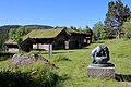 Grimdalstunet: alte Gebäude des Bergbauernhofes und Skulptur von Anne Grimdal