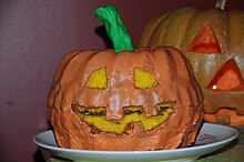 A Halloween cake shaped like a pumpkin