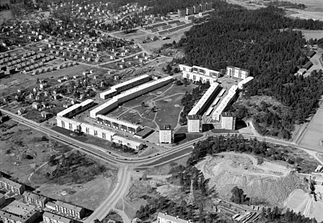 Kvarteret Stamtavlan mot väst 1961. I bakgrunden Liseberg, Anneboda samt skogspartiet för blivande Östbergahöjden. I bildens framkant syns Stureby och Huddingevägen samt Östberga stenkross, idag platsen för Östberga återvinningscentral. Fotografi: Oscar Bladh.