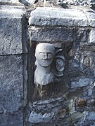 Fichée dans le mur extérieur du bas-côté sud, cette tête sculptée provient des fonts baptismaux du XIIIe siècle, aujourd'hui perdus.