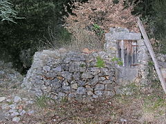 Puits couvert, en pierre sèche, sur une faille humide, et restes de poteries anciennes.
