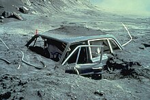 Photo d'une voiture entourée de lave solidifiée.