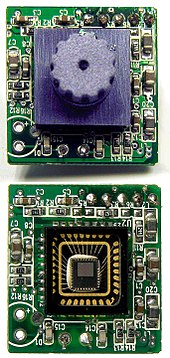 A webcam typically includes a lens (shown at top), an image sensor (shown at bottom), and supporting circuitry. Sweex USB webcam PCB with without lens close up.jpg