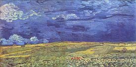 A picture of a vast open landscape field, dark blue sky over yellowish and green land.