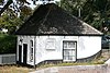 Brugwachtershuisje, bestaande uit het woongedeelte van een boerderij, waarvan het bedrijfsgedeelte is afgebroken. Gepleisterd pand zonder verdieping, onder pannen schilddak, aan de achterzijde afgesloten door een puntgevel