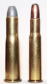 A .38-56 WCF cartridge next to a .30-30 Winchester cartridge