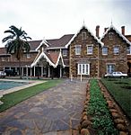 Double storey brick building with broseley tiled roof. Shale stone walls, with ventilated gables. Th The former Government House stands in Longmarket Street, between Fleming and Pine Streets, near the railway station. It is now one of the buildings of a Training College for teachers. In early times officials, even including the Lieutenant- Governor of th Type of site: Government House Previous use: offices & other: official residence. Current use: college. Head up Loop Street (one-way) turn right into Pine Street, just before T, and cross next T on Longmar. Historical and architectural-Was the home of Lieutenant-Governor of Natal, Benjamin Pine.