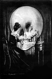 Vu de près, l'image représente une femme à sa toilette qui se regarde dans un grand miroir ; avec un peu de recul, le miroir rond semble représenter un grand crâne, dont les orbites sont la coiffure sombre de la dame et son reflet.