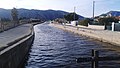 Fotografia del tram de canal feta des de les comportes. Orientació: Oest. Al fons, part del massís calcari del Mondúber.