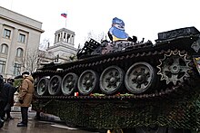 A NAFO "Fella" and a destroyed Russian tank in front of the Russian Embassy in Berlin Destroyed tank in front of Russian embassy Berlin 2023-02-24 10.jpg