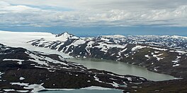 Colour photograph of Leirvatnet Lake surrounded by snow covered hills