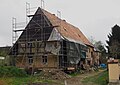 Wohnstallhaus (Obergeschoss Fachwerk, verputzt) und Resten der Hofmauer vor dem Grundstück, Teile eines ehemaligen Dreiseithofes