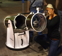 Woman looking through a Newtonian telescope Newtonian telescope with woman looking through it.png