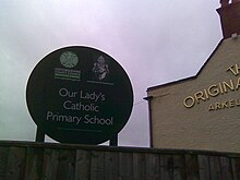 A sign for a Catholic school in Oxford, with the coat-of-arms of the Archdiocese of Birmingham and the logo of the Oxfordshire County Council. Our Lady's Catholic Primary School Oxford.jpg