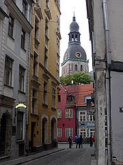 A catedral de Riga vista de uma de suas ruas estreitas.