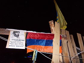 Решетка 32-й баррикады. Портрет Сергея Нигояна с флагами Армении и Украины