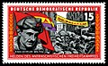 Γραμματόσημο της Ανατολικής Γερμανίας που τιμάει τον Χάινς Μπάιμλερ,με μια πολεμική σκηνή των Δ.Τ να φαίνεται στο φόντο