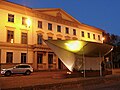 Palazzo di Wangenheim di notte con la fermata dell'autobus del progetto artistico BUSSTOPS di fronte al palazzo.