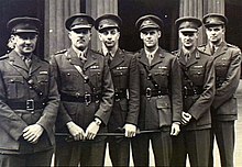 Black and white group photo of six men wearing military uniforms
