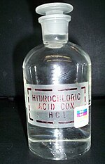 Transaprent chemical bottle with a glass cap and lable "hydrochloric acid. Con. HCl"