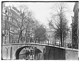 Warmoesgracht 2 t/m 26 (v.r.n.l.) (na 1895: Raadhuisstraat). Gezien van de Herengracht richting Singel en het Koninklijk Paleis. Op de voorgrond is brug nr. 22; 1894.