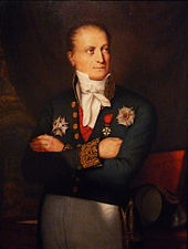 Peinture d'un homme debout, bras croisés sur la poitrine, la tête inclinée vers la gauche, vêtu d'un costume sombre orné d'imposantes décorations