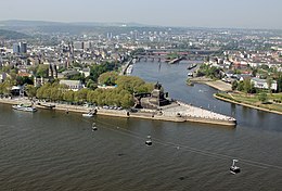 high angle view the confluence of two major rivers, marked by the statue of a man on a horse, with a city behind