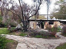 Exterior of burned home and landscaping in kibbutz after the attack Nir oz burned home and trees.jpg