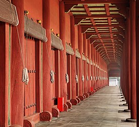 Corredor no Santuário de Chongmyo, Seul, Coreia do Sul. As portas laterais dão acesso aos shinsil, aposentos dos antigos espíritos ancestrais. É um santuário confucionista dedicado à perpetuação de serviços memoriais para os reis e rainhas falecidos da dinastia coreana Joseon (1392–1897). Segundo a UNESCO, o santuário é o mais antigo santuário real confucionista preservado e as cerimônias rituais continuam uma tradição estabelecida no século XIV. Tais santuários existiram durante o período dos Três Reinos da Coreia (57-668), mas não sobreviveram. O Santuário de Chongmyo foi adicionado à lista do Patrimônio Mundial da UNESCO em 1995. (definição 2 790 × 2 559)