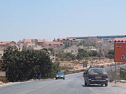 Alon Shvut as seen from the West on Route 367. The long blue roofs of the two synagogues in the "New Settlement" are on the right.