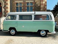 Un Volkswagen Combi dans une belle livrée vert d’eau à toit blanc.