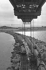 מסילה להעברת חומרי בנייה ומנוף בעת בנייתו של שובר הגלים הראשי בנמל, 1963
